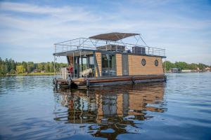 a small boat sitting on the water at Entspannung pur - Hausboot Liberty in Fürstenberg