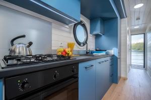 a kitchen with a stove and a blue wall at Entspannung pur - Hausboot Liberty in Fürstenberg
