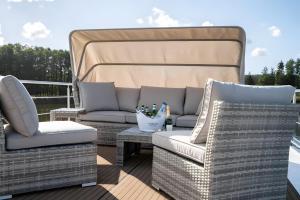 a patio with two chairs and a couch and a table at Entspannung pur - Hausboot Liberty in Fürstenberg +2 photos