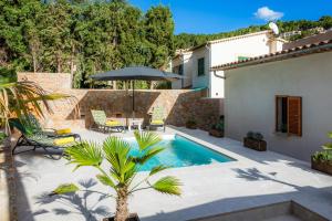 a backyard with a swimming pool and an umbrella at Villa Puerto in Sóller