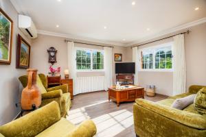 a living room with couches and a tv at Villa Puerto in Sóller
