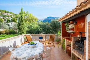 a patio with a table and chairs on a balcony at Villa Puerto in Sóller