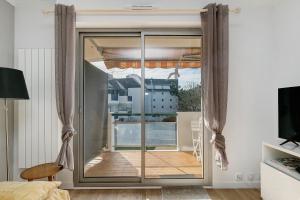 a room with a sliding glass door to a balcony at Appart' Chez Suzi, La Baule centre in La Baule