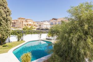 a swimming pool in a yard with trees and houses at San Jose in Nerja +16 photos