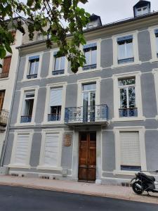 a gray building with white windows and a door at T2 bis Vue Aneto in Luchon