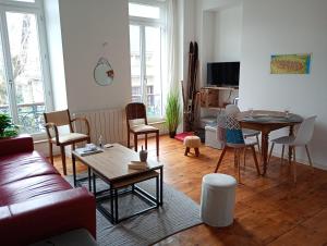 a living room with a couch and a table and chairs at T2 bis Vue Aneto in Luchon