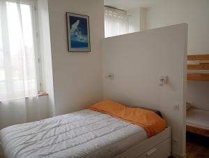 a bedroom with a bed with an orange blanket at T2 bis Vue Aneto in Luchon