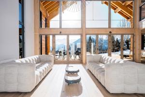 a living room with white furniture and large windows at Black Arves in La Rochette