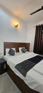 a bedroom with a large bed with white sheets and blue pillows at Hotel blue ocean baga beach away in Arpora