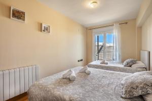 two beds in a room with a window at Summit Sierra Nevada in Sierra Nevada