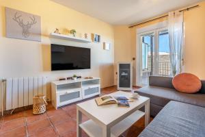 a living room with a couch and a tv at Summit Sierra Nevada in Sierra Nevada