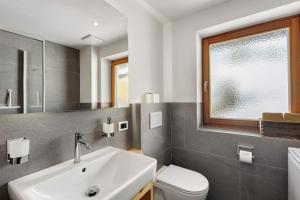 a bathroom with a sink and a toilet and a window at Lüch dl Pinter in San Martino in Badia +14 photos