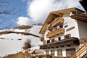 a building with balconies on a snow covered mountain at Lüch dl Pinter in San Martino in Badia