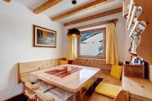 a dining room with a wooden table and a window at Lüch dl Pinter in San Martino in Badia