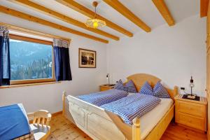 a bedroom with a bed and a window at Lüch dl Pinter in San Martino in Badia