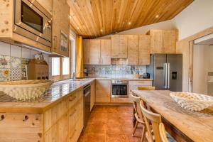 a kitchen with wooden cabinets and a large wooden table at Maison Orange in Aspiran