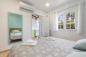 a white bedroom with a bed and a mirror at Safir in Son Bou +13 photos