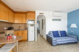 a living room with a couch and a kitchen at Safir in Son Bou
