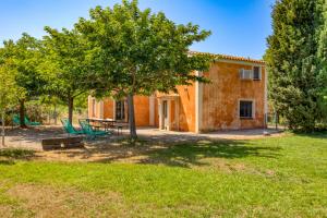 a farmhouse with a table and chairs in a yard at Maison Orange in Aspiran