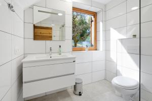 a white bathroom with a sink and a toilet at Mini Trenta in Soča