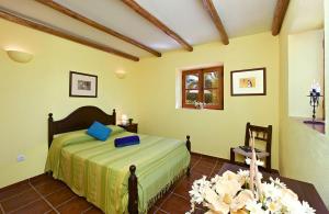 a bedroom with a bed and a table with flowers at Quinta da Aroeira in Lagoa