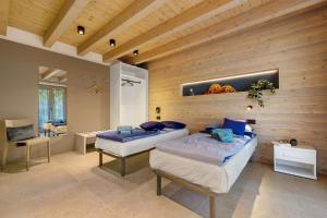 a bedroom with two beds in a room with wooden walls at Casa Meg in Tremosine Sul Garda