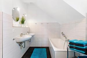 a white bathroom with two sinks and a tub and a bath tub at Deluxe Ferienwohnungen Diana in Radolfzell am Bodensee +40 photos