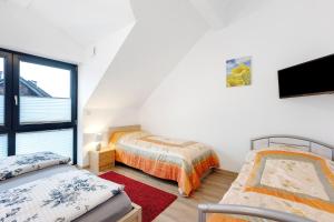 a attic bedroom with two beds and a tv at Deluxe Ferienwohnungen Diana in Radolfzell am Bodensee