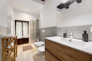 a bathroom with a white sink and a toilet at La Sosta di Isa in Delebio