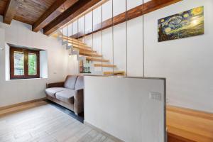 a living room with a couch and a staircase at La Sosta di Isa in Delebio