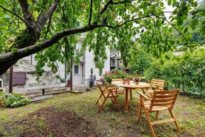 a table and chairs under a tree in a yard at La Sosta di Isa in Delebio