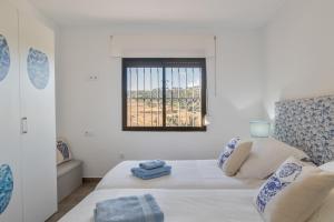 a white room with a bed and a window at Las Mimosas Ronda in Ronda