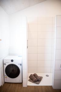 a washer and dryer in a white bathroom with towels at Kleines Glück Wettenberg in Hochdorf
