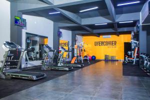 a gym with several treadmills and machines in a room at Urban Bliss Hotel in Kabwe