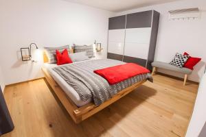 a bedroom with a large bed with red pillows at Alpenblick De Luxe in Oetz