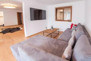 a living room with a couch and a flat screen tv at Alpenblick De Luxe in Oetz
