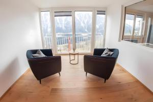 a living room with two chairs and a mirror at Alpenblick De Luxe in Oetz