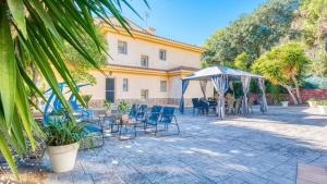 a patio with chairs and tables and a building at Costacabana - Villa Summertime in Lloret de Mar