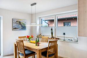 a dining room with a wooden table and chairs at Landhaus Gerda in Wangerland