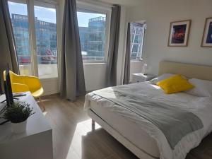 a bedroom with a bed and a desk and windows at Paris vous aime in Le Kremlin-Bicêtre