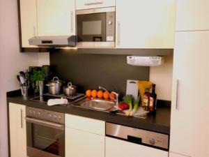 a kitchen with a counter with a sink and a stove at Ferienhaus Jümmers - Hein Mück in Horumersiel