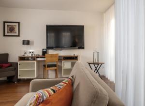 a living room with a couch and a flat screen tv at Ferienhaus Jümmers - Hein Mück in Horumersiel