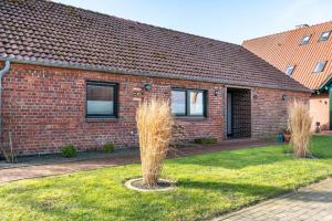 a brick house with a plant in the yard at Landhaus Gerda in Wangerland