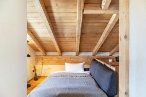 a bed in a room with a wooden ceiling at Alpview Loft Garmisch in Garmisch-Partenkirchen
