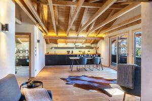 a kitchen with wooden ceilings and a table and chairs at Alpview Loft Garmisch in Garmisch-Partenkirchen