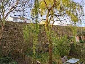 a brick wall with a table and chairs and a tree at Apartamentos PORTA NOVA 2 in Lugo