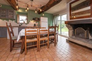a kitchen and dining room with a table and a fireplace at Les Hortensias - Gîtes in La Croix-Helléan