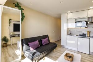 a living room with a black couch and a kitchen at Atic Moon Miami in Empuriabrava +17 photos