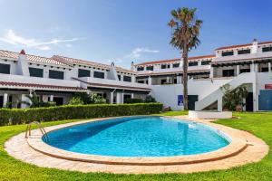 a swimming pool in front of a building at Maison Menorca in Arenal d'en Castell