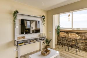 a living room with a tv and a window at Atic Moon Miami in Empuriabrava